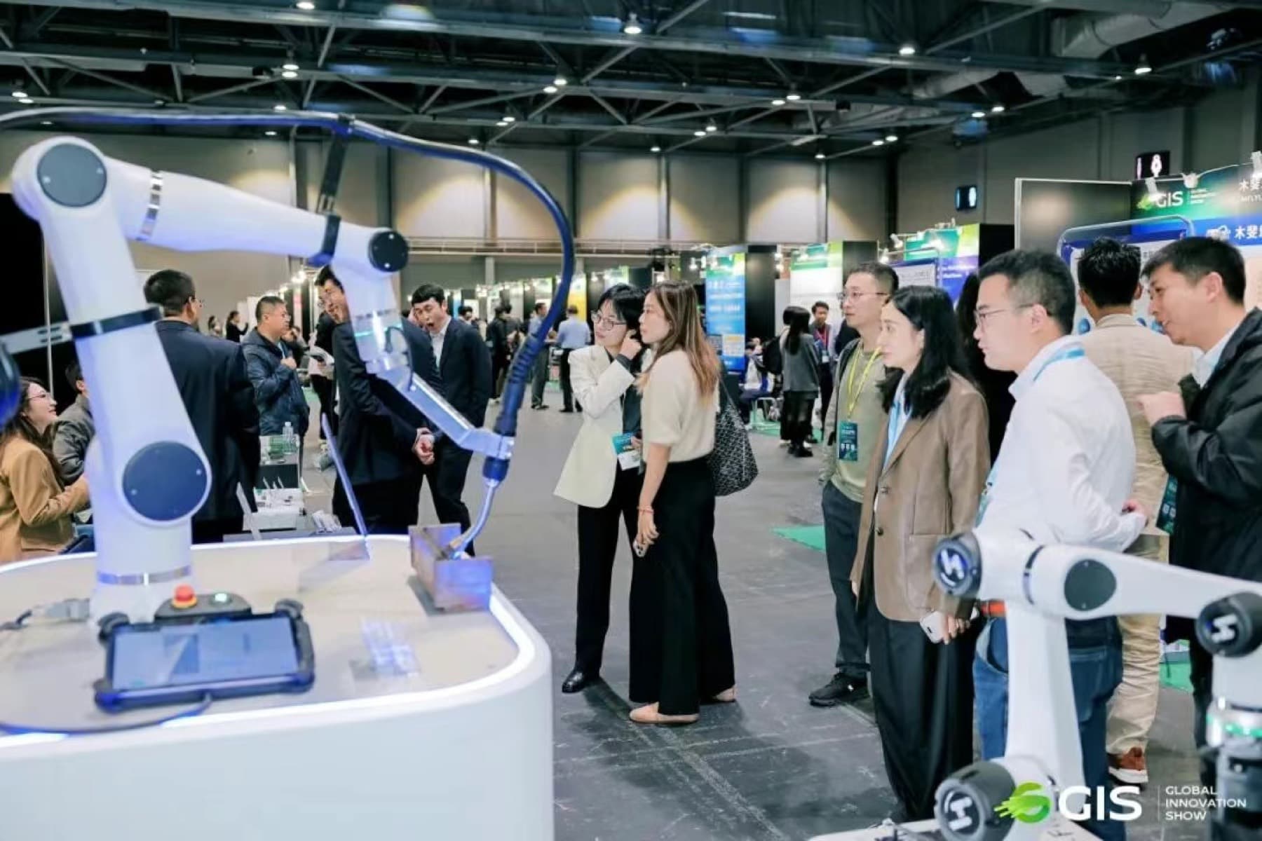 Visitors watching a robotic arm demonstration on the Global Innovation Show exhibition floor in Hong Kong
